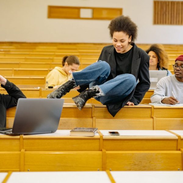 Estudantes universitários de diferentes perfis interagem e estudam em uma sala de aula.