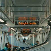 Passageiros viajam no interior de um trem moderno de transporte público.
