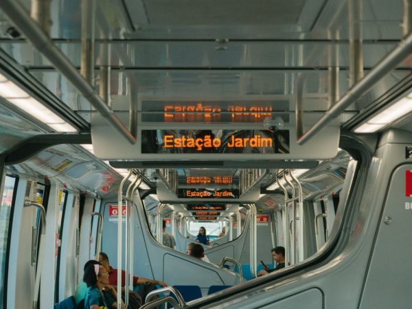 Passageiros viajam no interior de um trem moderno de transporte público.