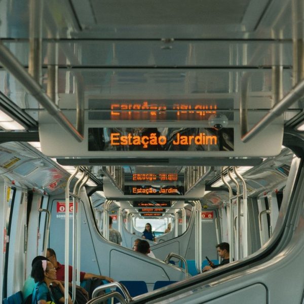 Passageiros viajam no interior de um trem moderno de transporte público.