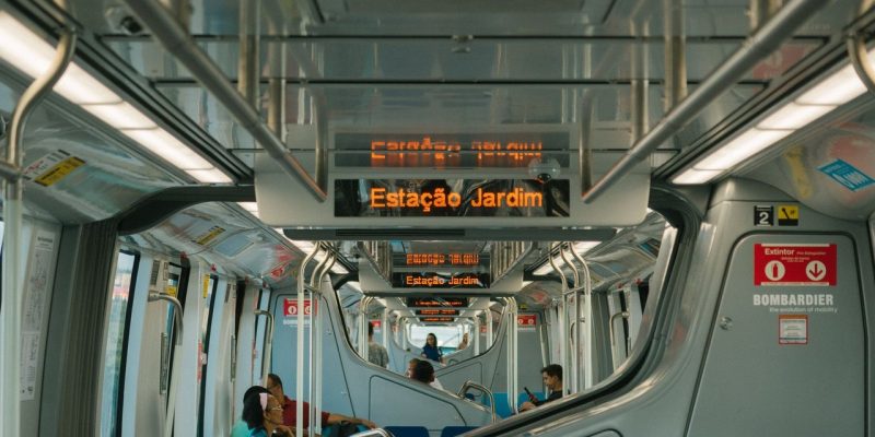 Passageiros viajam no interior de um trem moderno de transporte público.